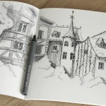 Tworzenie precyzyjnych konturów ikon i detali w notatkach wizualnych czarnym cienkopisem Neuland FineOne Sketch na papierze.