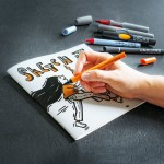 Rysowanie i tworzenie notatek wizualnych markerami pędzelkowymi na gładkim papierze w otwartym szkicowniku Neuland Sketchbooklet.